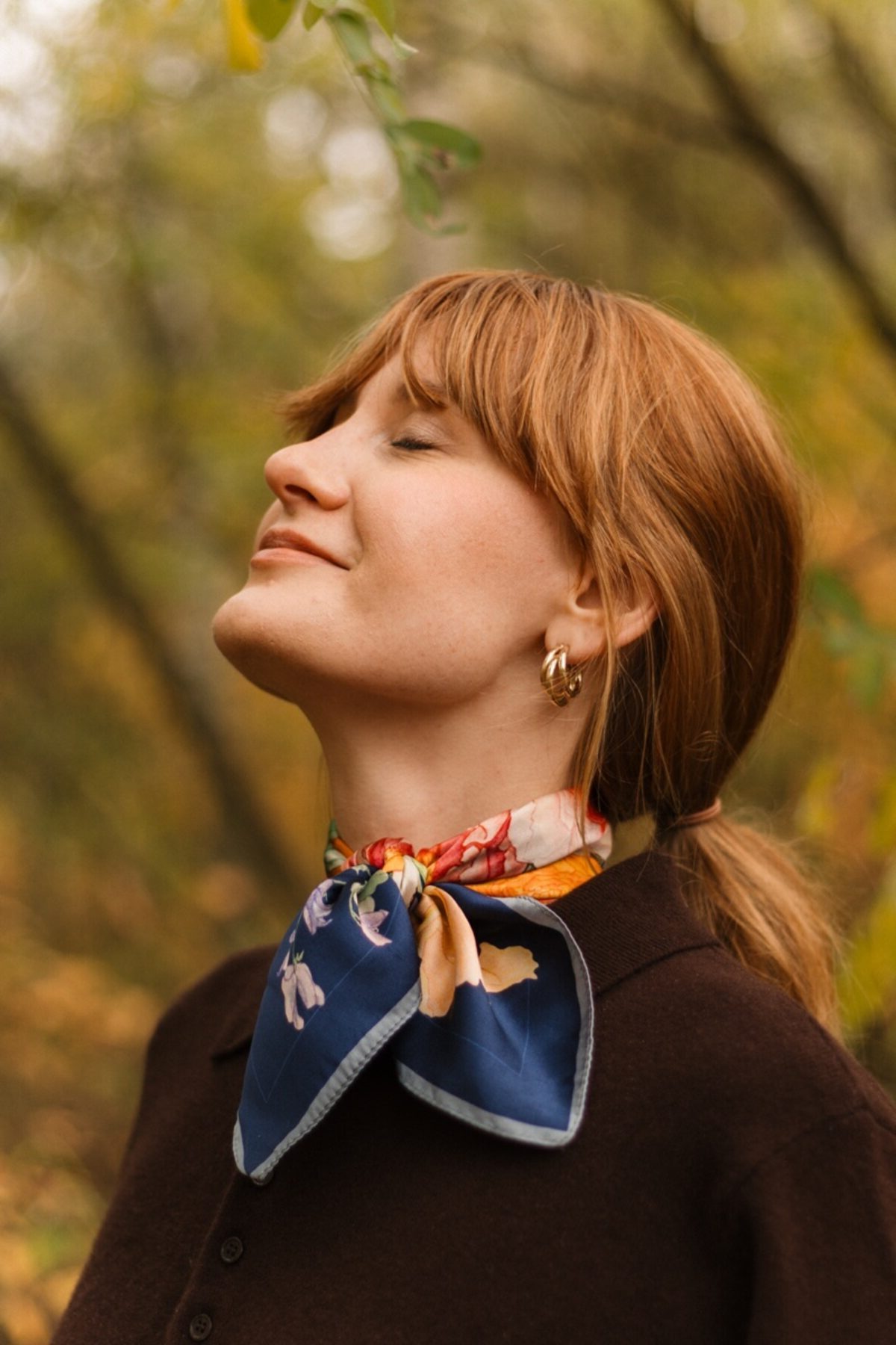 Kobieta w autorskiej apaszce z jedwabiu w jesiennej scenerii