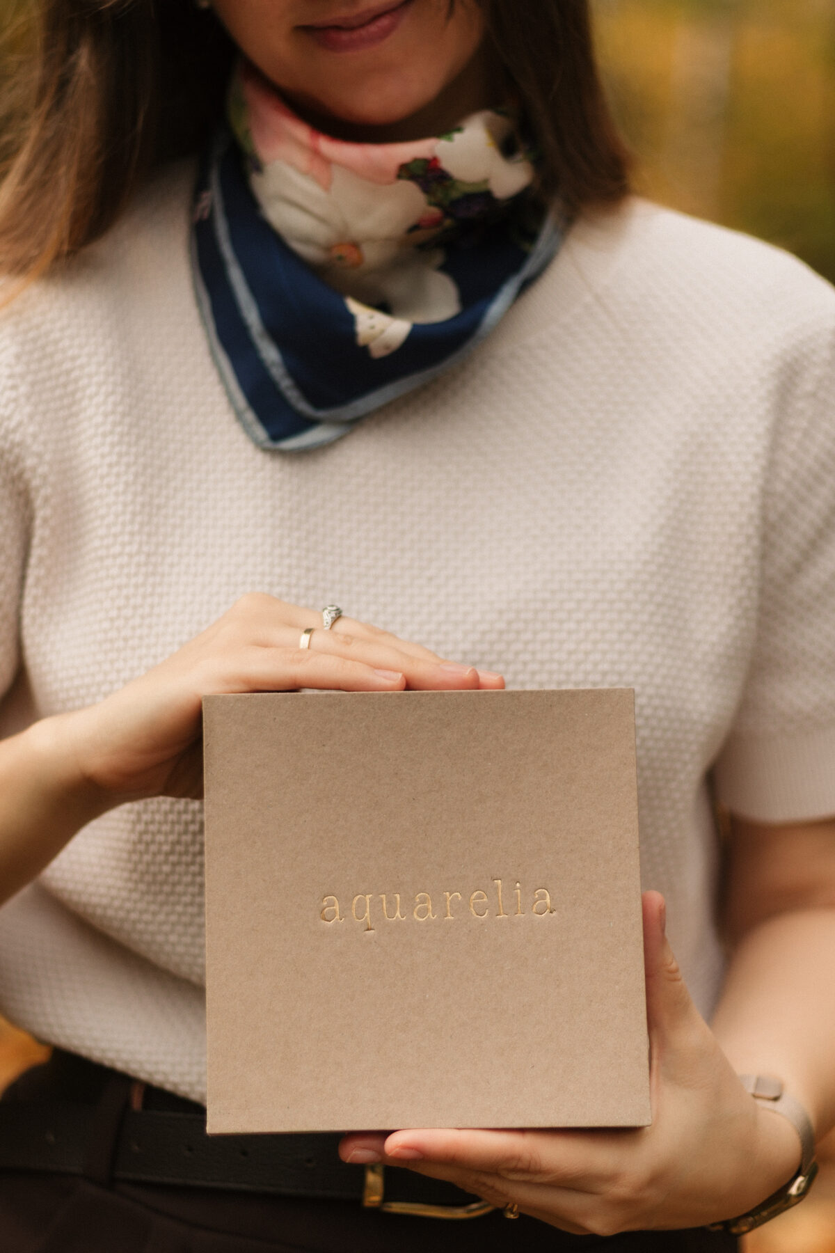 Kobieta trzymająca pudełko Aquarelia w jesiennym świetle